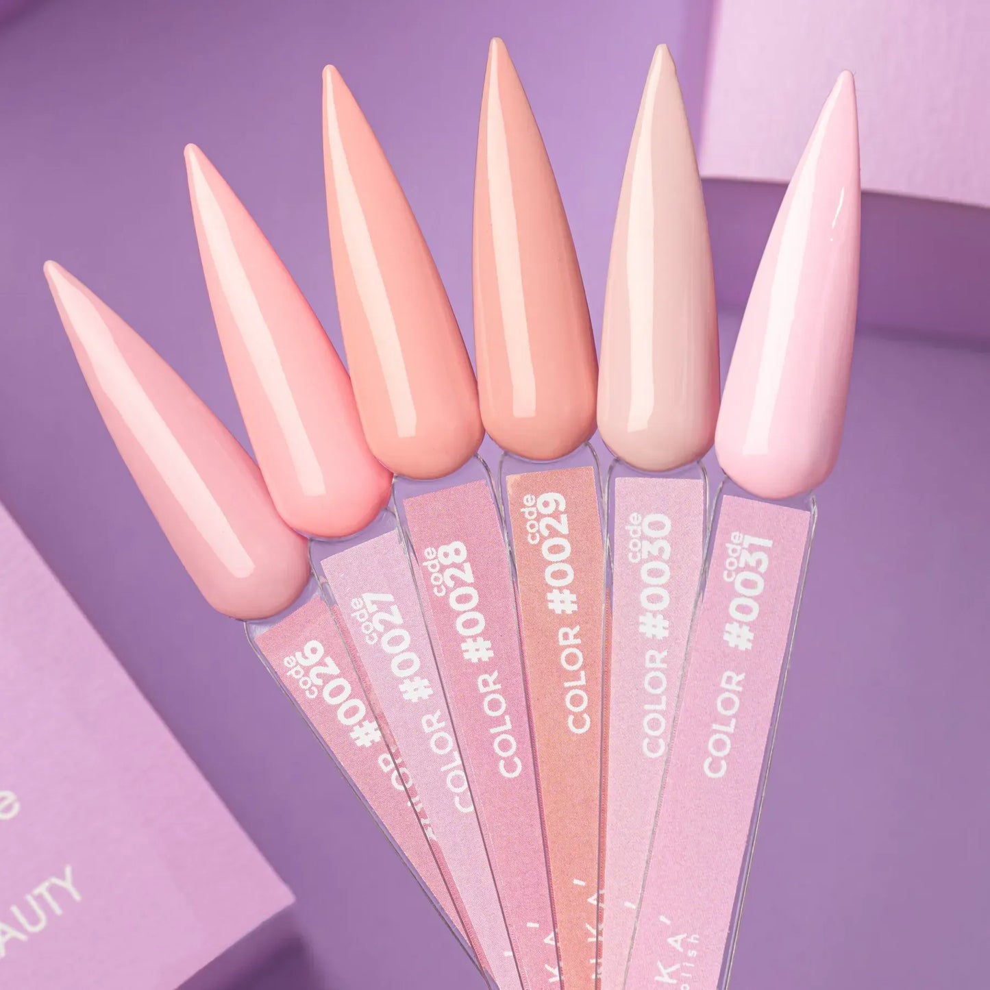 Five DNKa' Gel Polish nail swatches showing Colors #0027 through #0031, a gradient from soft pink to warm peach and pale powder blush, on a purple background