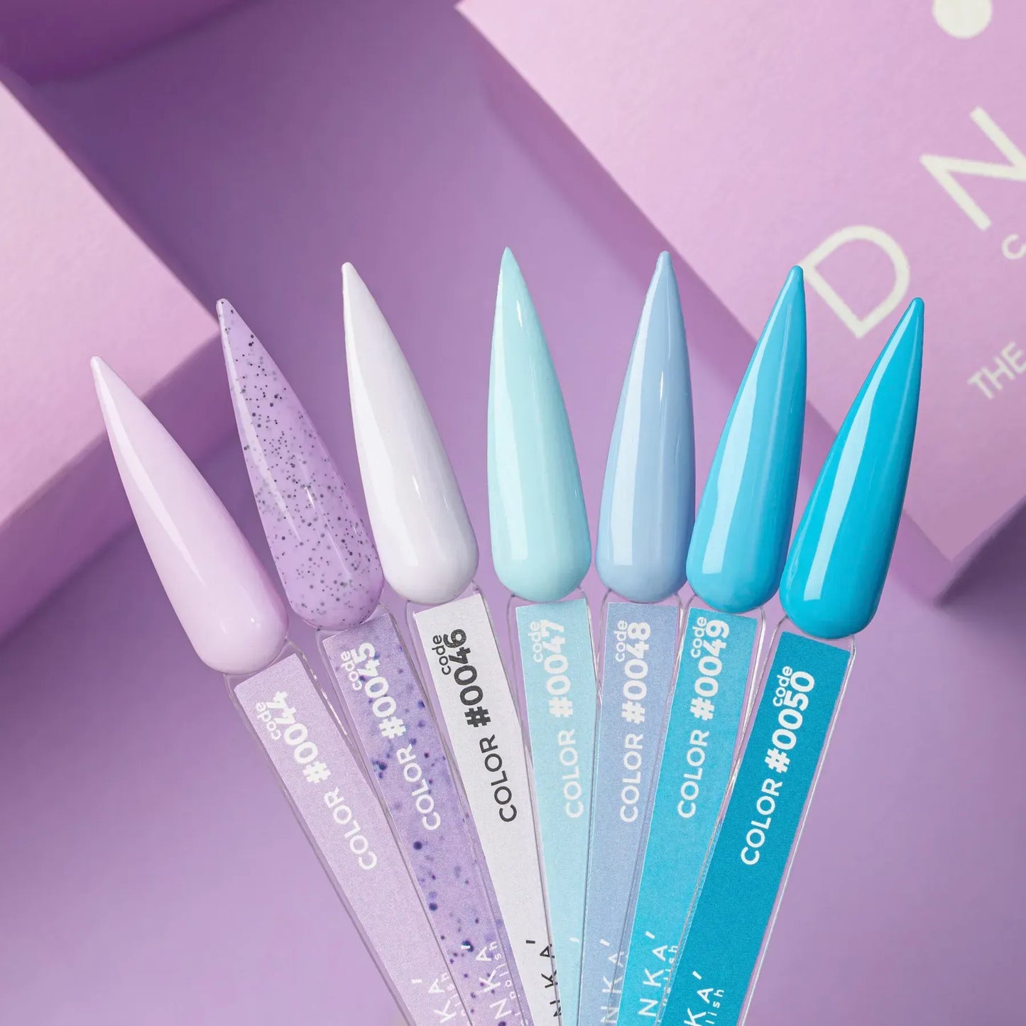 Seven DNKa' Gel Polish nail swatches showing Colors #0044 through #0050, a gradient from pale lavender and glitter violet to white, mint, sky blue, and vivid turquoise, on a purple background